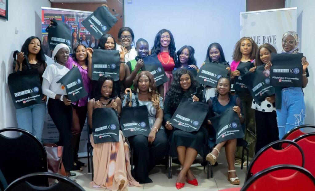 A group of women dressed in corporate sitting/ standing, holding branded bags while smiling to the camera.